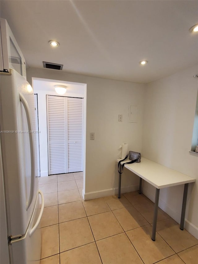 kitchen with white fridge and light tile patterned floors