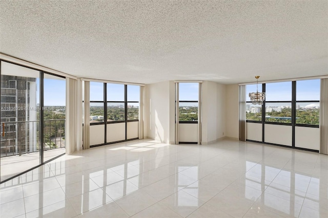 unfurnished room with light tile patterned flooring, a chandelier, and a textured ceiling