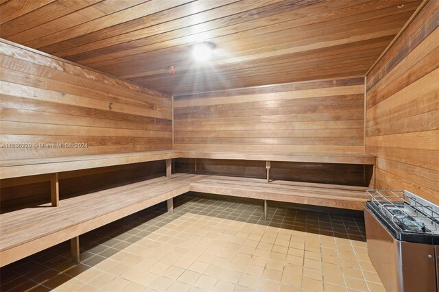 view of sauna featuring wood ceiling, wooden walls, and tile patterned floors