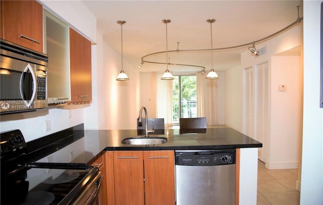 kitchen featuring hanging light fixtures, appliances with stainless steel finishes, light tile patterned floors, and sink