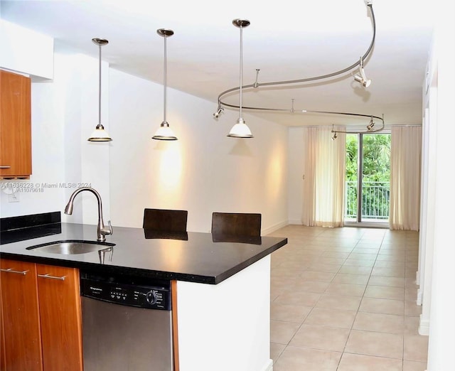 kitchen with track lighting, sink, decorative light fixtures, light tile patterned floors, and stainless steel dishwasher