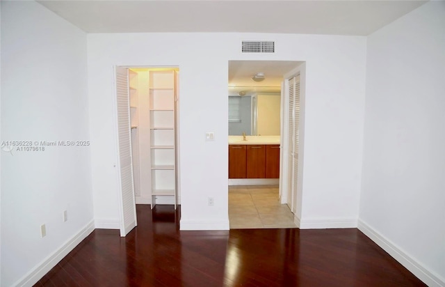 empty room with baseboards, visible vents, and light wood-style flooring