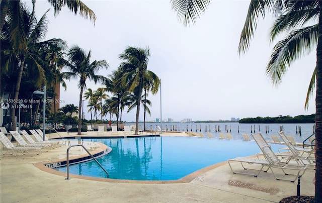 pool featuring a water view and a patio