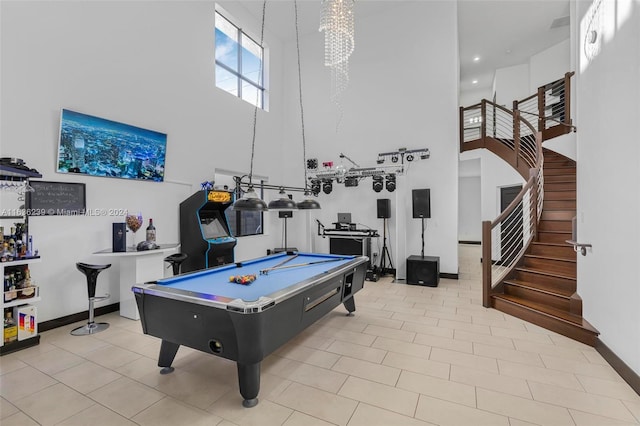 playroom featuring a chandelier, a towering ceiling, pool table, and light tile patterned floors