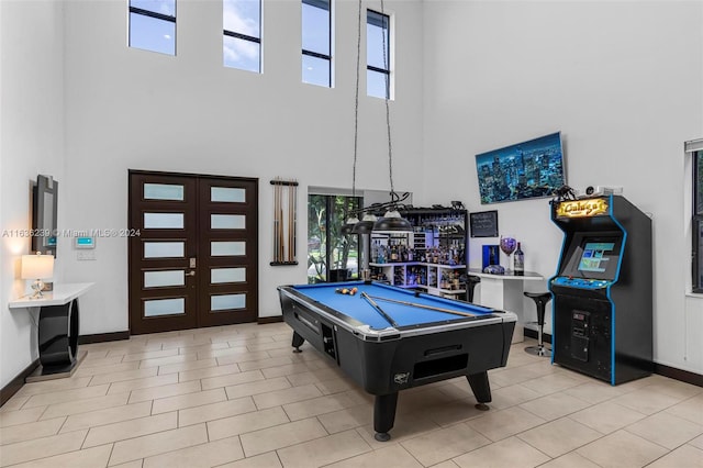 recreation room featuring pool table, light tile patterned floors, and a high ceiling