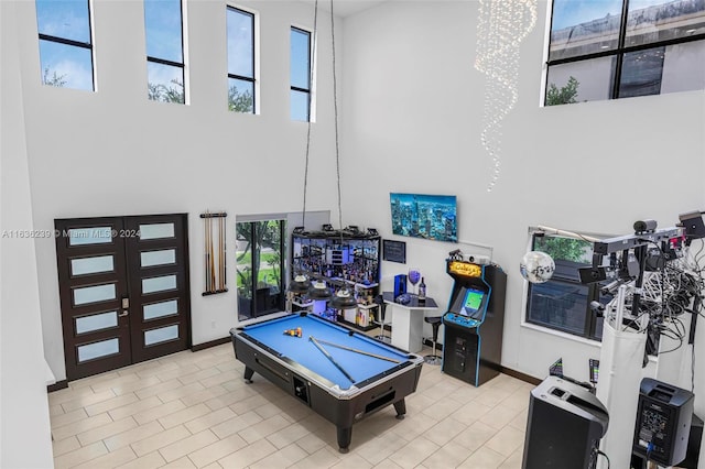 recreation room with pool table, a high ceiling, and light tile patterned floors