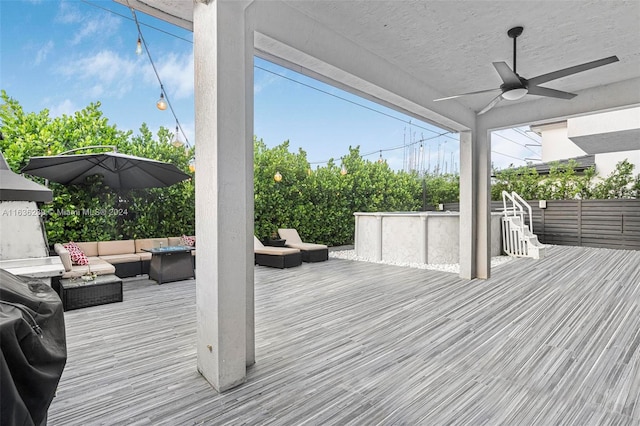 wooden terrace featuring ceiling fan and an outdoor hangout area