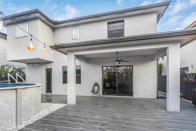 rear view of house featuring a wooden deck, sink, and ceiling fan