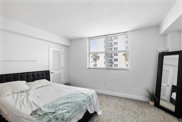 carpeted bedroom featuring a textured ceiling