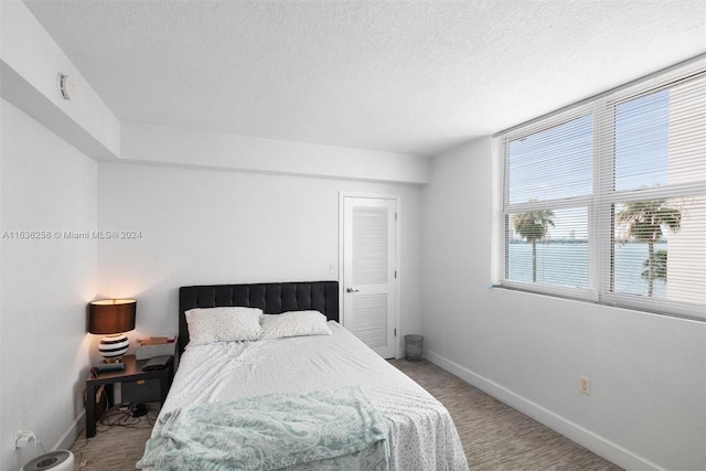 carpeted bedroom featuring a textured ceiling