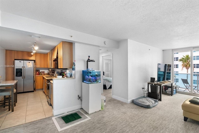 kitchen with stainless steel fridge with ice dispenser, a textured ceiling, and light carpet