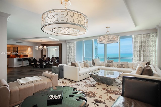 living room with a chandelier, hardwood / wood-style floors, a water view, and plenty of natural light