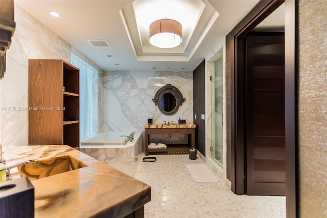 bathroom featuring a tray ceiling, vanity, and independent shower and bath