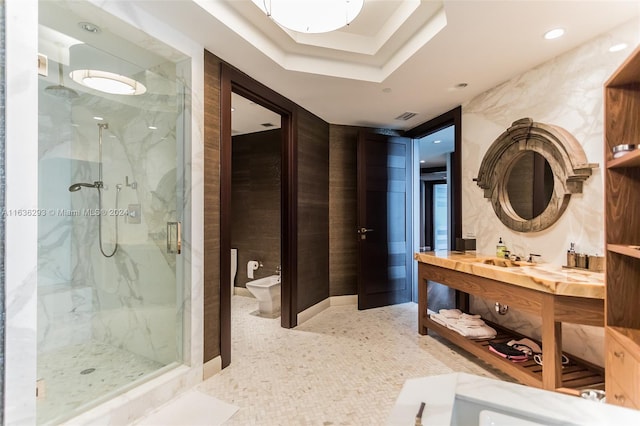 bathroom featuring a bidet, a tray ceiling, a shower with door, and vanity