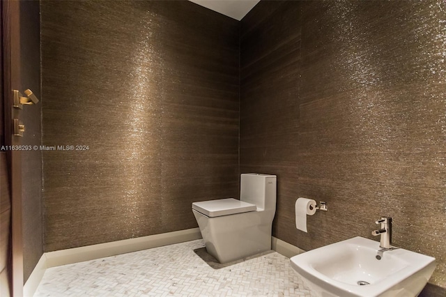 bathroom featuring toilet, sink, and a bidet