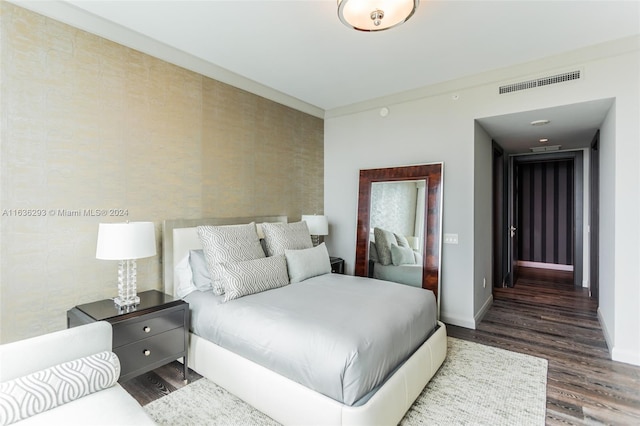 bedroom with dark hardwood / wood-style flooring and crown molding