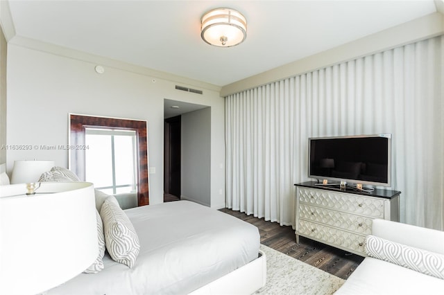 bedroom featuring ornamental molding and dark wood-type flooring