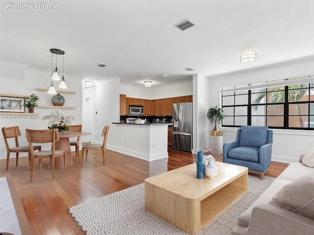 living room with hardwood / wood-style flooring and crown molding