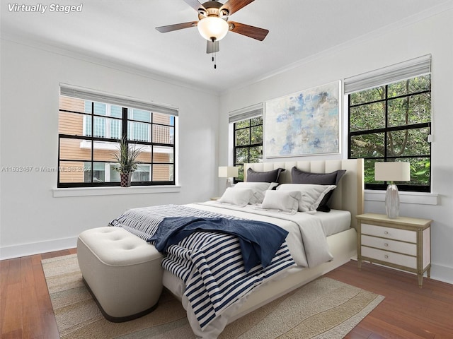 bedroom featuring ceiling fan, ornamental molding, and wood-type flooring