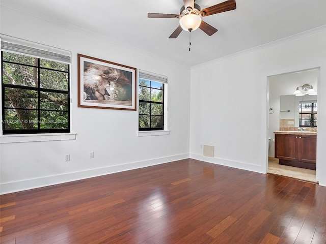 empty room with dark hardwood / wood-style flooring, crown molding, and ceiling fan