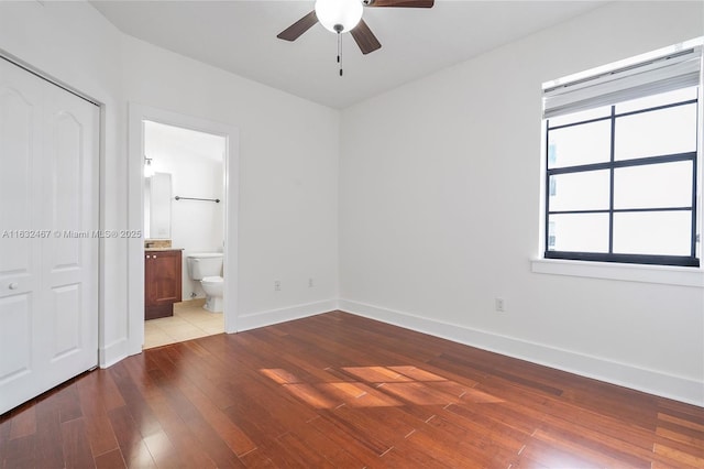 unfurnished bedroom featuring ceiling fan, connected bathroom, and light wood-type flooring