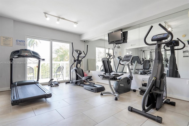 workout area with track lighting and light tile patterned floors