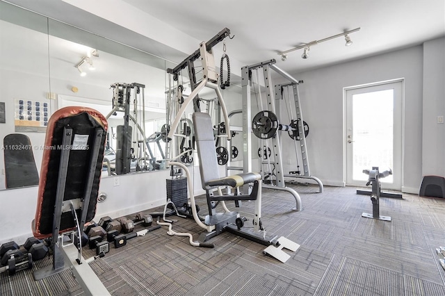 gym with rail lighting and carpet flooring