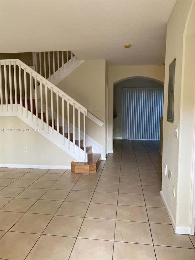 1519 SE 24th Ct Unit 238, Homestead, FL 33035 - stairway featuring tile patterned flooring, arched walkways, baseboards, and electric panel