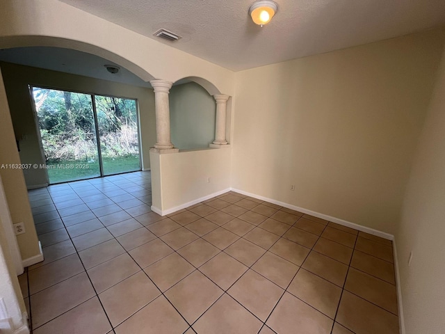 1519 SE 24th Ct Unit 238, Homestead, FL 33035 - spare room with visible vents, a textured ceiling, arched walkways, light tile patterned floors, and baseboards