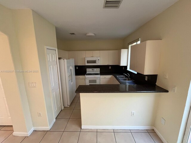 1519 SE 24th Ct Unit 238, Homestead, FL 33035 - kitchen featuring white appliances, visible vents, a peninsula, a sink, and dark countertops