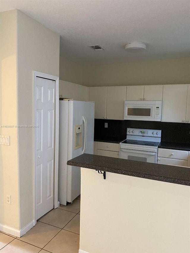 1519 SE 24th Ct Unit 238, Homestead, FL 33035 - kitchen with visible vents, dark countertops, white appliances, white cabinets, and light tile patterned floors