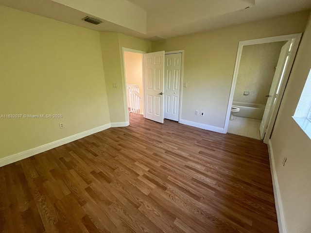 1519 SE 24th Ct Unit 238, Homestead, FL 33035 - unfurnished bedroom with visible vents, baseboards, ensuite bath, and wood finished floors