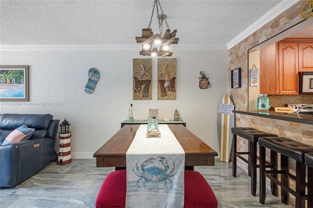 dining space featuring a notable chandelier, light wood-type flooring, a textured ceiling, and ornamental molding