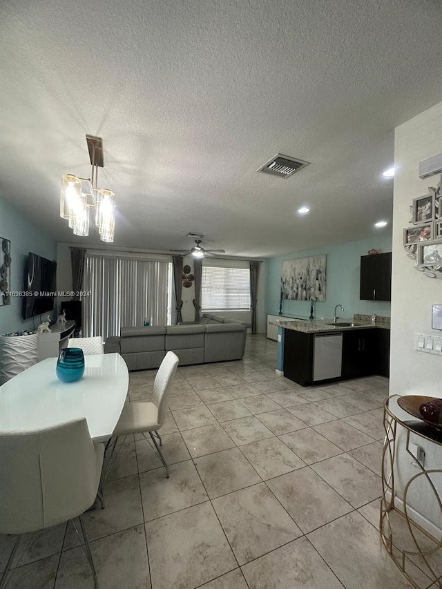 tiled dining area featuring indoor wet bar, ceiling fan with notable chandelier, and a textured ceiling