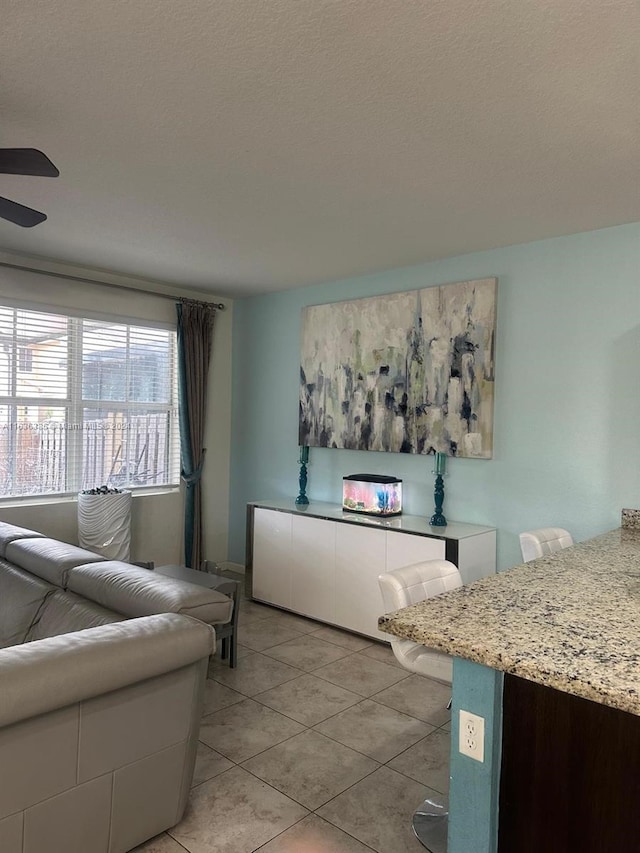 tiled living room with ceiling fan