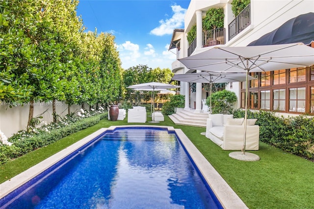 view of swimming pool featuring a fenced in pool, a lawn, and fence