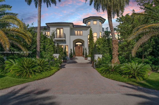 mediterranean / spanish-style home with a balcony and stucco siding