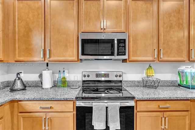 kitchen featuring light stone counters and appliances with stainless steel finishes