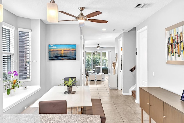 dining space featuring ceiling fan, a textured ceiling, and light tile patterned floors