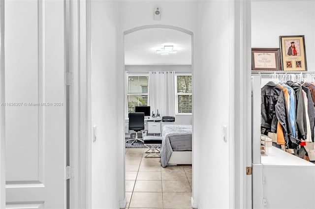 hall with a textured ceiling and light tile patterned floors