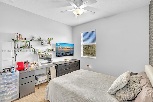 bedroom with a textured ceiling, light tile patterned floors, and ceiling fan