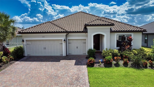 mediterranean / spanish house featuring a garage and a front yard