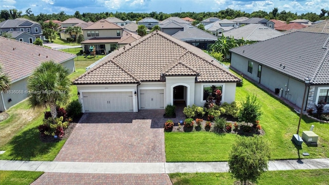 mediterranean / spanish-style house featuring a garage and a front lawn