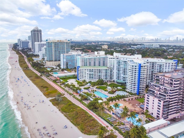 birds eye view of property with a water view and a beach view