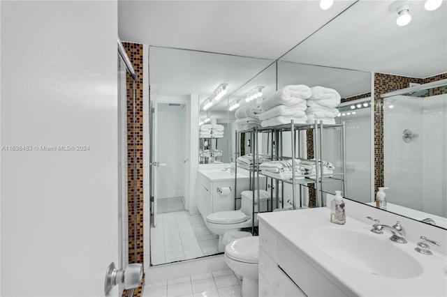 bathroom featuring tile patterned flooring, a shower with door, toilet, and vanity