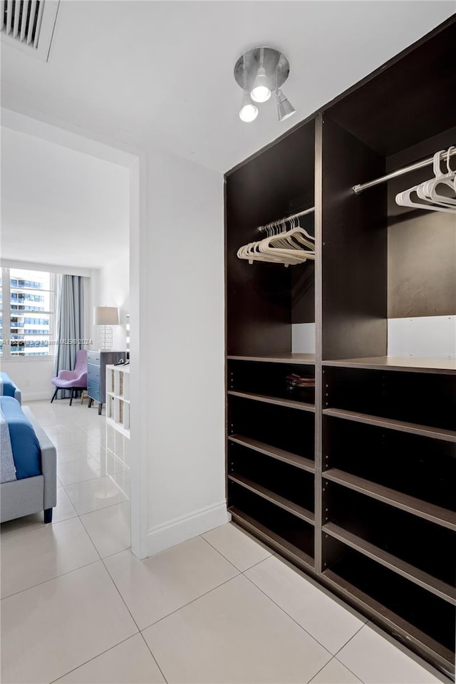 walk in closet featuring light tile patterned flooring