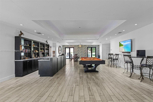 game room featuring pool table, light hardwood / wood-style flooring, and a tray ceiling