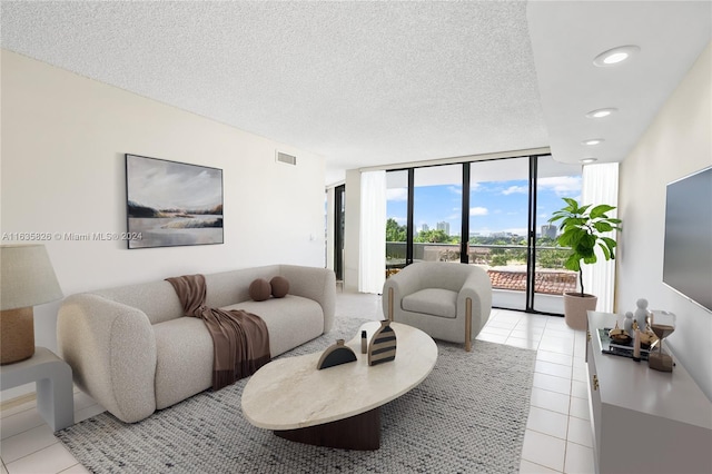 tiled living room featuring a textured ceiling and a wall of windows