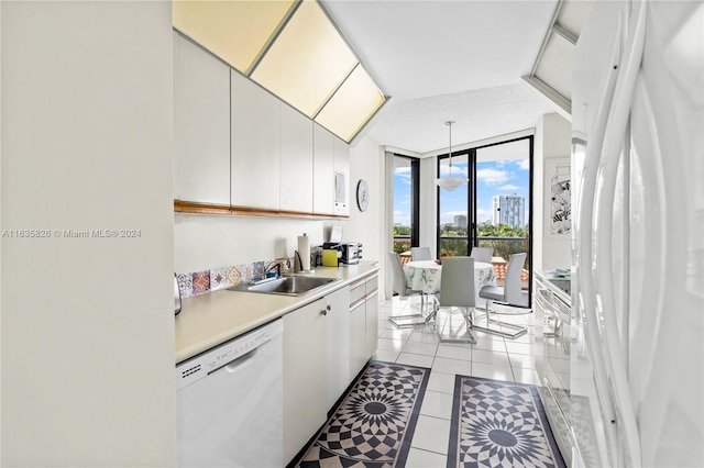 kitchen with sink, white cabinets, white appliances, and light tile patterned floors