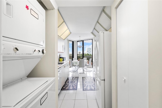 laundry room featuring light tile patterned flooring and stacked washer and dryer